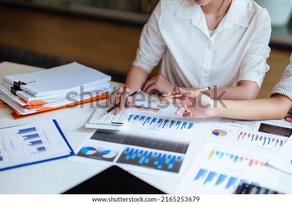 financial,\
Planning, Marketing and Accounting, Asian young Economist using\
calculator to calculate investment documents with partners on\
profit taking to compete with other\
companies