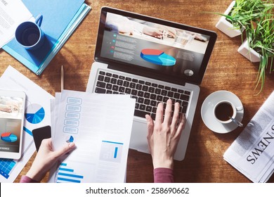 Financial report with pie chart and data on a laptop with business woman's hands at work - Powered by Shutterstock