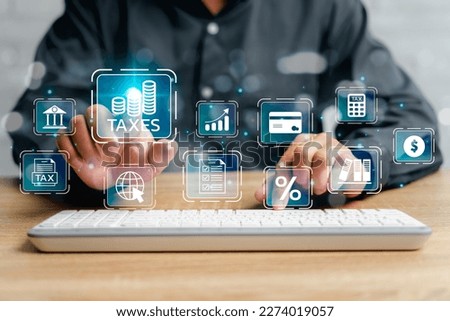 Financial research, government taxes, and calculation tax return concept, Businessman using desktop and  pointing on tax and Financial icon and use laptop keyboard input tax detail on virtual screen