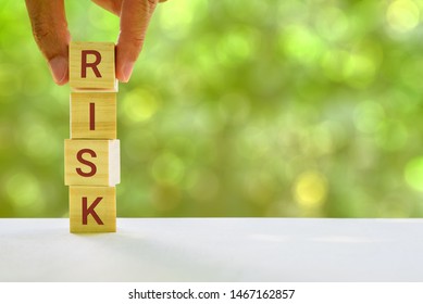 Financial Risk Assessment And Portfolio Risk Management Concept : Stack Of Vertical 4 Cubes On A Table With A Letter R, I, S, K On Each Cubes, Depicts Managing / Control Asset Risk To Gain High Return