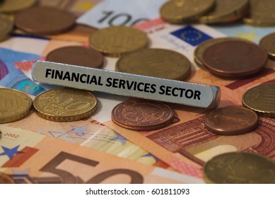 Financial Services Sector - The Word Was Printed On A Metal Bar. The Metal Bar Was Placed On Several Banknotes