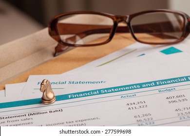 Financial statement letter on brown envelope and eyeglass, business concept; document is mock-up