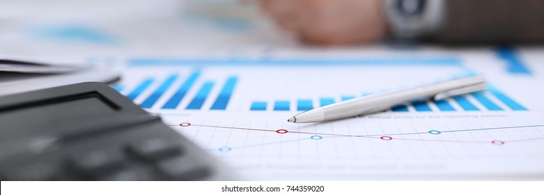 Financial statistics documents ball pen infographics at office table closeup. Internal Revenue Service inspector sum check investigation exchange market earnings savings loan and credit concept - Shutterstock ID 744359020