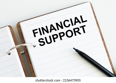 Financial Support Text Written On A Notebook With Pencils