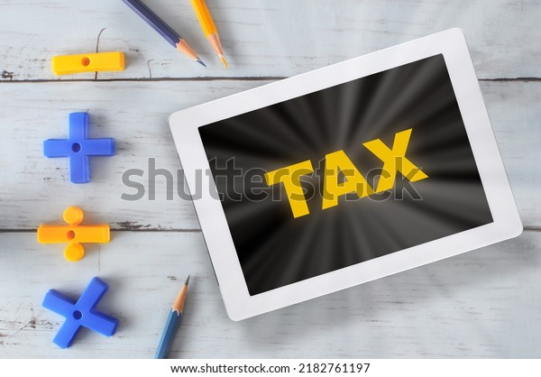 Financial tax calculation on\
digital tablet with mathematics plus, minus, multiplied and divided\
on desk. Saving money concept and online payment technology\
idea