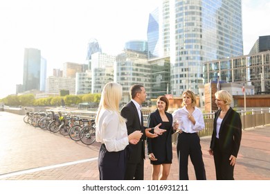 Financial Team Employees Speaking With Boss In La Defense Paris. Concept Of Decision Making And Business Meeting. Responsible People Planning Work Outside.