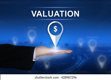 financial valuation button with business hand on blurred background
