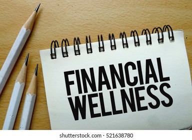 Financial Wellness Text Written On A Notebook With Pencils