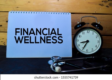 Financial Wellness Write On Book Isolated On Wooden Table. Medical Or Finance Concept