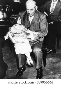Financier J.P. Morgan with circus midget Lya Graf sitting on his knee, June 1, 1933. She was brought into the Senate Banking and Currency Committee hearing by a press agent for the Ringling Brothers C