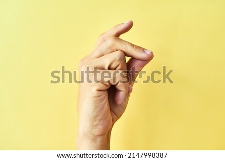 Find your groove. Studio shot of an unrecognizable man snapping his fingers against a yellow background.