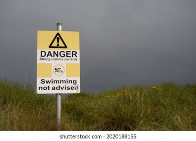 Findhorn, Scotland, UK - August 1 2021: Danger Strong Inshore Currents Swimming Not Advised Sign With Icons. Authentic, On Beach Path. No People.