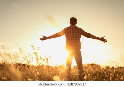 Finding inner happiness. Young man in open country field with his arms outstretched facing the beautiful warm sunrise.  Mind body and spirit concept.  - Shutterstock ID 2187889817