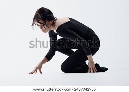 Finding inner-self. Young slim woman in black clothes, dark makeup look and artistic face posing against white studio background. Concept of self-care, beauty, psychology, emotions and feelings