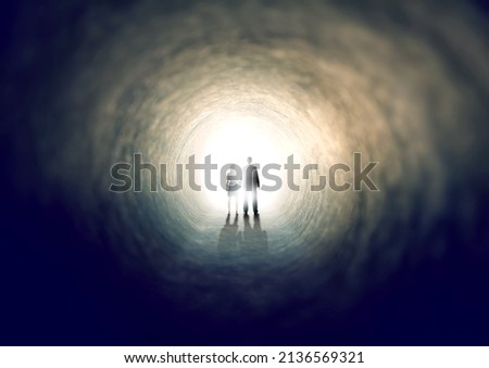 Finding the light. A shot of two people finding an exit from a dark tunnel - ALL design on this image is created from scratch by Yuri Arcurs team of professionals for this particular photo shoot.