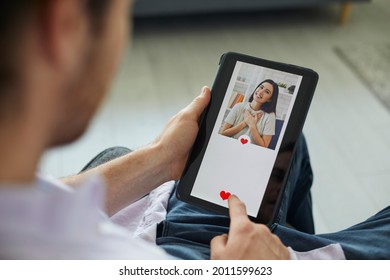 Finding Love On Modern Online Dating Website Or Mobile App: Man Looking At Profile Pic Of Pretty Young Woman On Digital Tablet Display Gives Her Like And Sends Her Message. Close Up, Closeup Shot