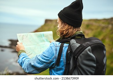 Finding My Way Through Nature. Shot Of A Young Man Looking At A Map For Directions Outdoors.