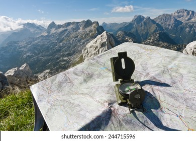 Finding Your Way With A Compass And A Map On The Top Of The Mountain Rombon, Slovenia