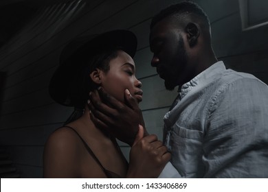 fine art portrait of gorgeous black couple. two in love. engagement photo shoot. sensitive portrait of man and woman who look into each other eyes. get close for a kiss