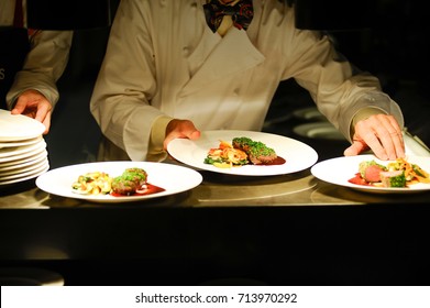 Fine Dining Chef Holding A White Plate With A Meal And Food Deco At Kitchen Bar.Food Concept.Fine Dining Concept.