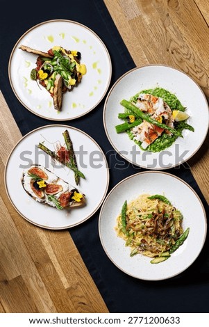 Fine dining set menu with four plated dishes
Gourmet restaurant dishes served on table top view
Assorted fine dining plates with seafood and meat