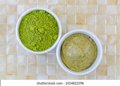 Fine Ground Japanese Matcha Green Tea Leaves Powder Next To Green Tea Scrub With Walnut Shell And Cocoa Exfoliator, Top View
