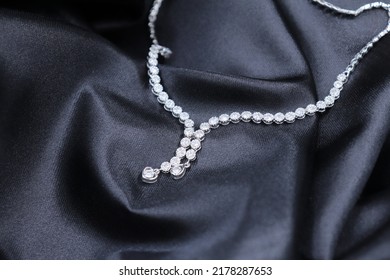 Fine Jewelry As Diamond Necklace With Diamond With Black Satin Fabric Background. Jewelry Shop Concept