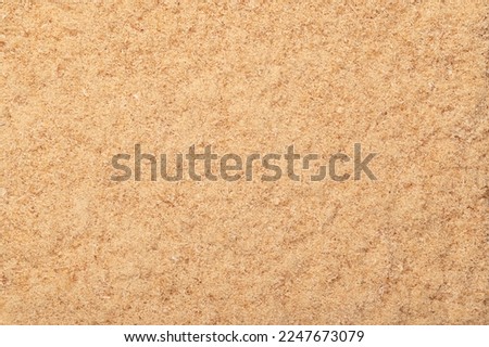 Fine sawdust, a wood flour and powder, formed by sawing dried spruce. Finely pulverized wood, a by-product and waste product, mainly used as a filler and extender. Surface and background, from above.