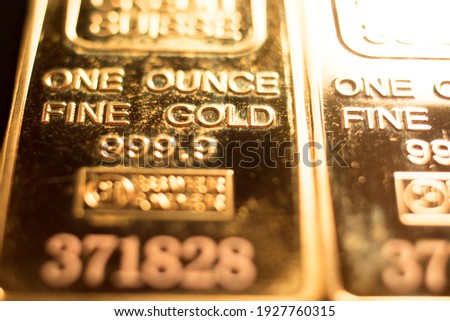 Fine solid gold 999.9 one ounce bullion ingot precious metals bar closeup isolated photo.