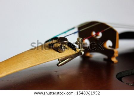 the fine tuner for the e string clearly seen in this image of a violin and bridge.