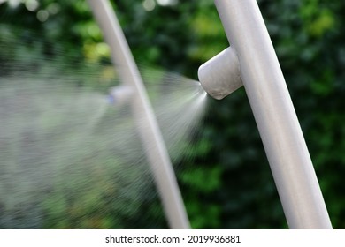 Fine Water Spray, Vapor Or Mist Nozzle. Restaurant Terrace Cooling And Vaporizing. Outdoor Summer Cooling. Aluminum Pipe. Blurred Green Foliage Background. Summer Vacation Concept. Misting System