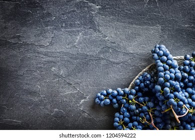 Finest home bunch of grapes on dark stone table on silver plate top view. Fresh grape on black background, wide banner or panorama for copy space.