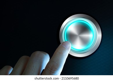 Finger about to press button with blue light over black and grey background. Concept image for illustration of change or strategic vision.