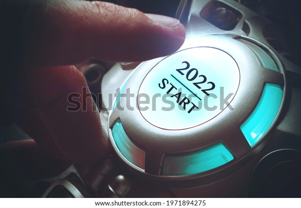Finger about to\
press an ignition button with the text 2022 start. Year two\
thousand and twenty two\
concept.