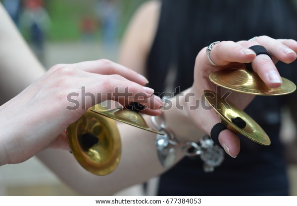 The\
Finger cymbals, I\'m a dancer, it\'s a tribal dance. My friend is\
holding a musical instrument. She took pictures in the park. The\
flash was not needed because the weather was\
fine.