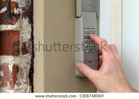 finger entering code on Keypad used on a garage door entrance to a home - security keypad - security code