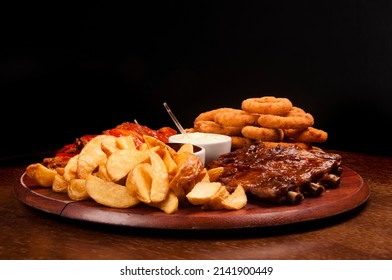 Finger Food Cattail With Chicken Wings In Buffalo Sauce, Onion Rings, Barbecue Pork Ribs And French Fries Front View