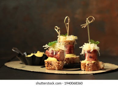 Finger food with sausages wrapped in bacon, sauerkraut and bread - Powered by Shutterstock