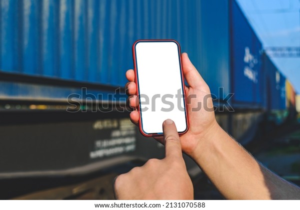 Finger in front of smartphone\
mockup in male hand. Against the background of a railway car in\
motion