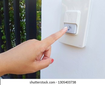 A Finger Is Going To Press The Door Bell  In Front Of The House. Electronic Equipment Concept.