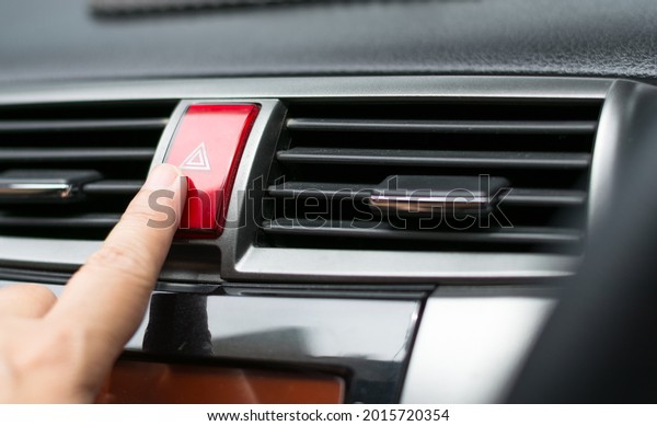 Finger hitting\
Emergency light button in the\
car