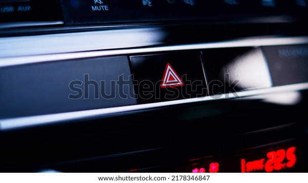 Finger hitting emergency light stop button in the\
luxury car.