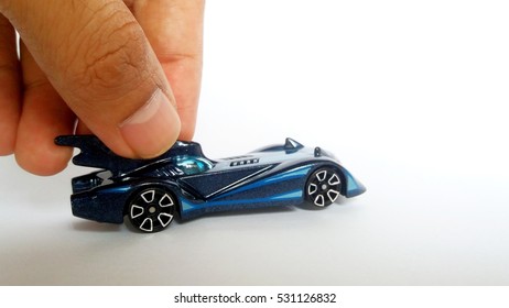 Finger Holding Blue Diecast Batmobile.