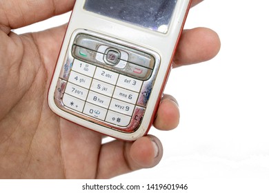 Finger Holding Old Generation Of Mobile Phone With White Isolate Die Cut Background. Traditional Cellphone During 1995-2010 Century.