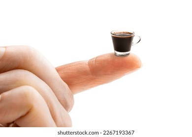 Finger holding small cup of coffee. Concept of small portion 