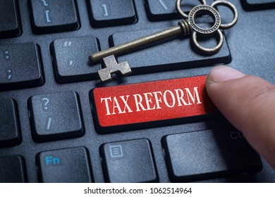 Finger on computer keyboard with word TAX REFORM