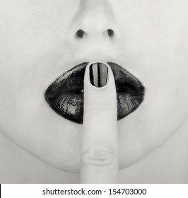 finger on lips black and white picture
