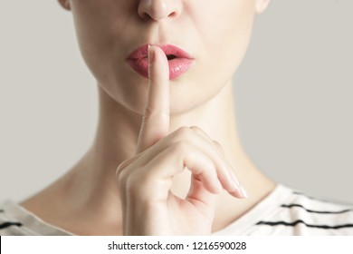 Finger On Lips - Silent Gesture, Woman Holding Her Finger To Her Lips In A Gesture For Silence.