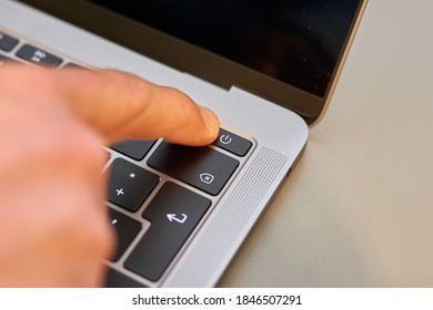 Finger On Power Button Of Notebook Laptop