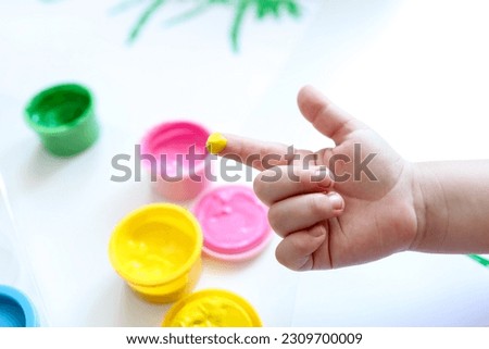 Finger painting. Close-up. Fingers of children's hands in bright paint. Early development. Hobby.